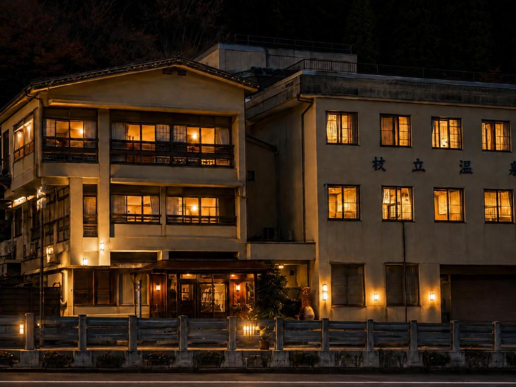 a large building with lit windows at night at 旅館丸正 in Oguni
