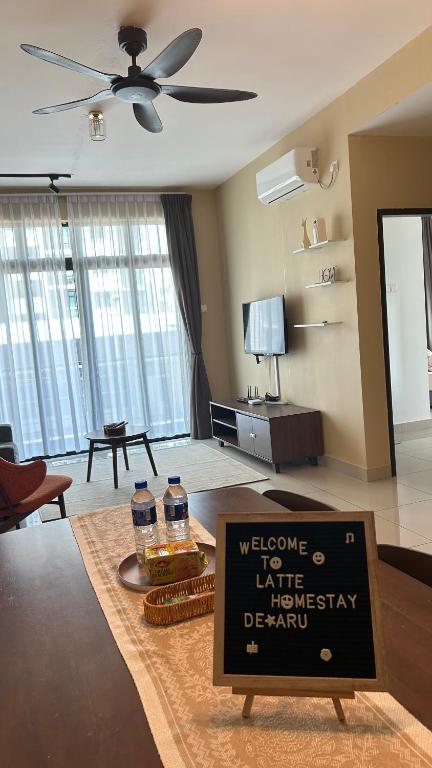 a living room with a sign in the middle of a room at Latte Homestay Desaru 5GWifi with Swimming Pool in Bandar Penawar