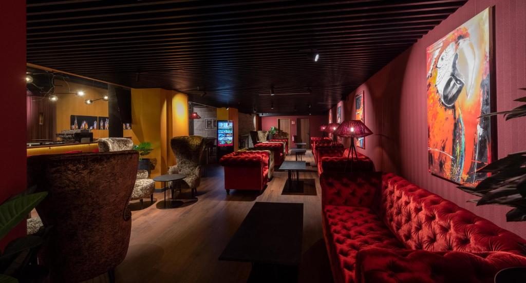 a bar with red couches in a room at Hotel Postgalerie Speyer in Speyer