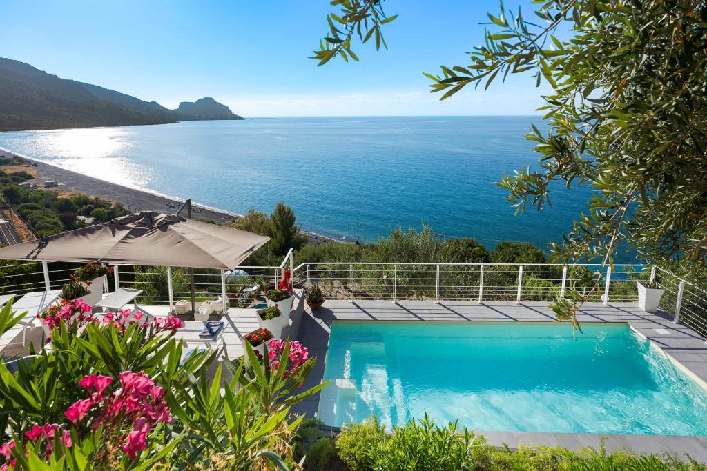 ein Swimmingpool mit Blick auf das Meer in der Unterkunft Emerald Hotel Residence Cefalù in Cefalú