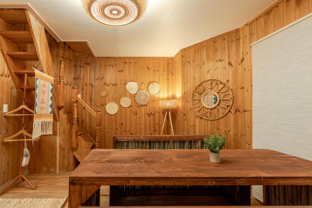 a room with wooden walls and a wooden table at 감성제주스테이 in Songnang-dong