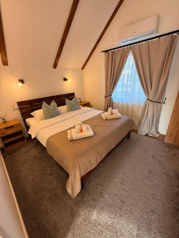 a bedroom with a large bed with two towels on it at Casa Vonvea in Ocna Şugatag