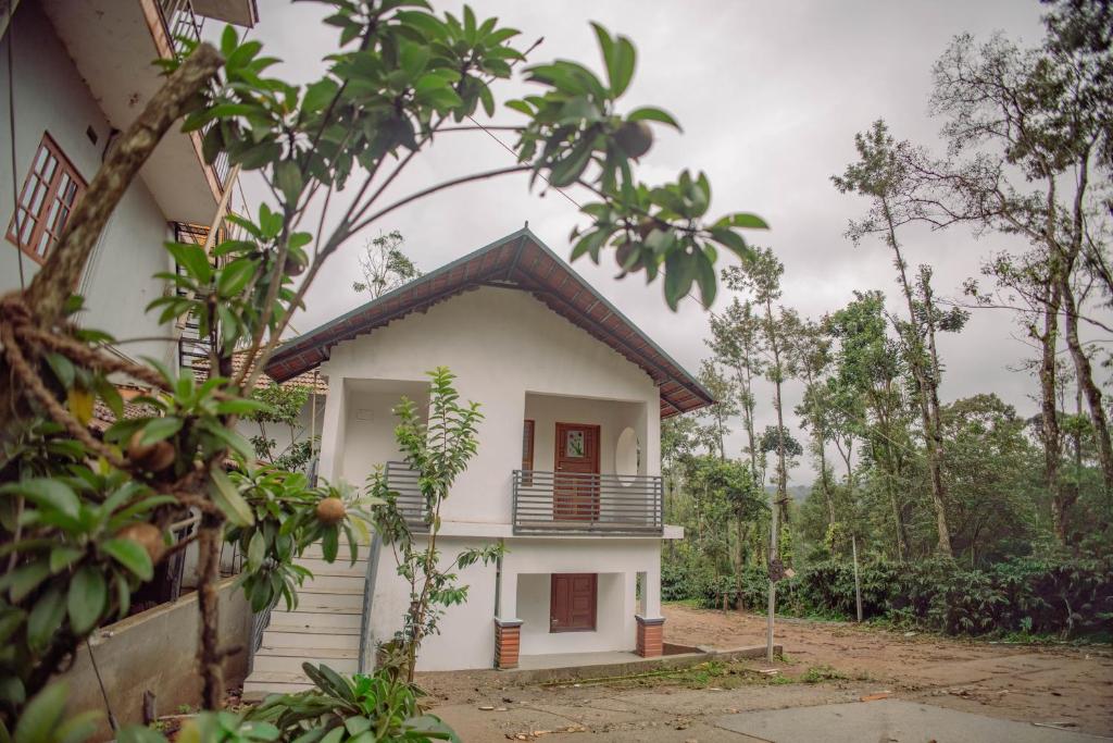 a white house with a black roof at Sun Side Cottages in Madikeri