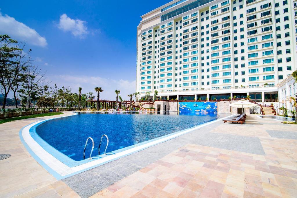 a swimming pool in front of a large building at Sokha Phnom Penh Hotel in Phnom Penh