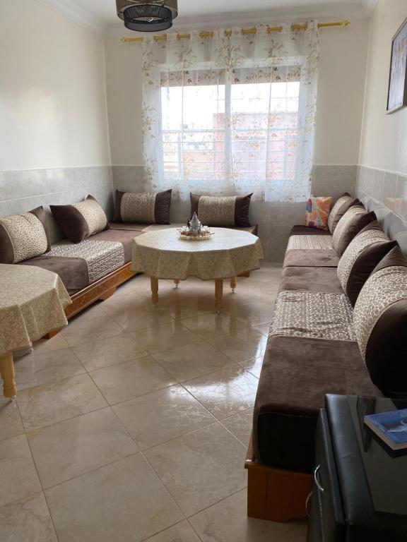 a living room with a large couch and a table at Najam café in Saïdia