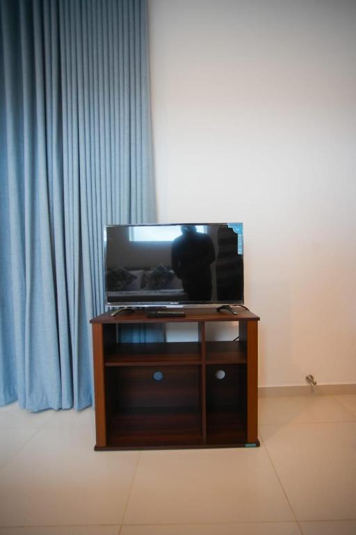 a tv sitting on a stand in front of a window at Beachfront Bliss Ocean Views & Sunset Views 