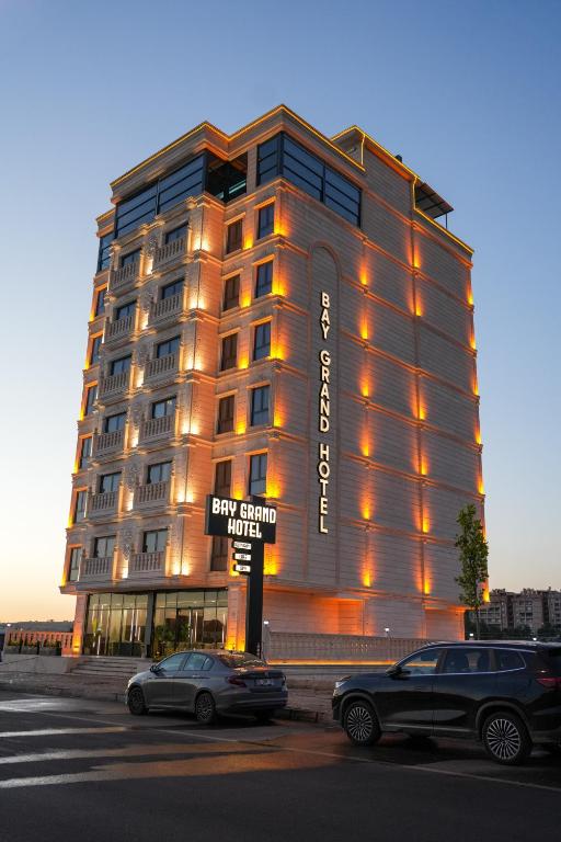a large building with cars parked in front of it at Midyat Bay Grand Hotel in Midyat