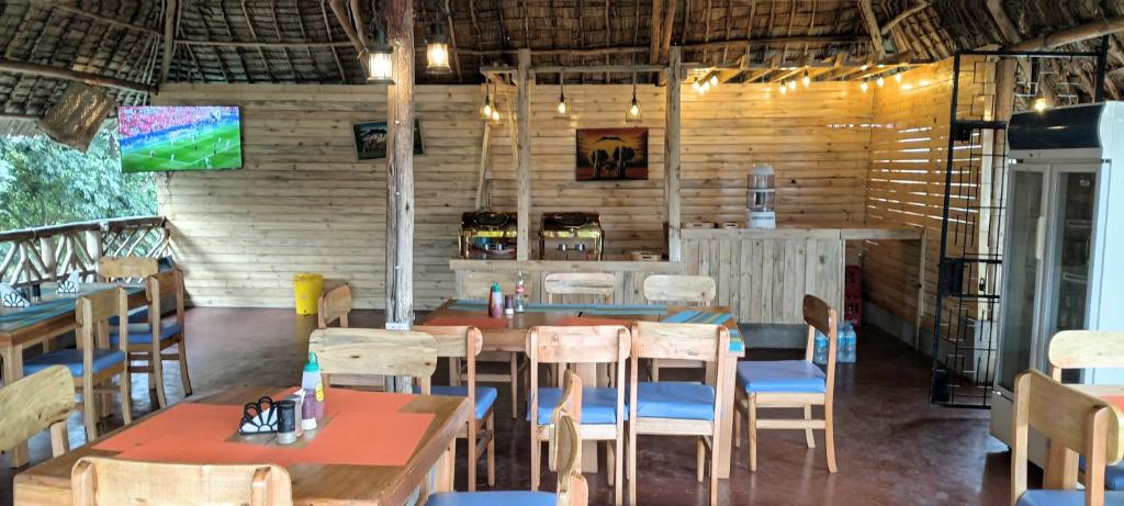 a restaurant with tables and chairs in a room at Kilimanjaro Simba Lodge in Moshi