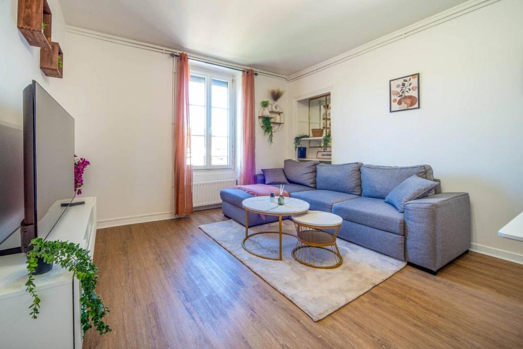 a living room with a blue couch and a table at Le Chagnotin in Chagny
