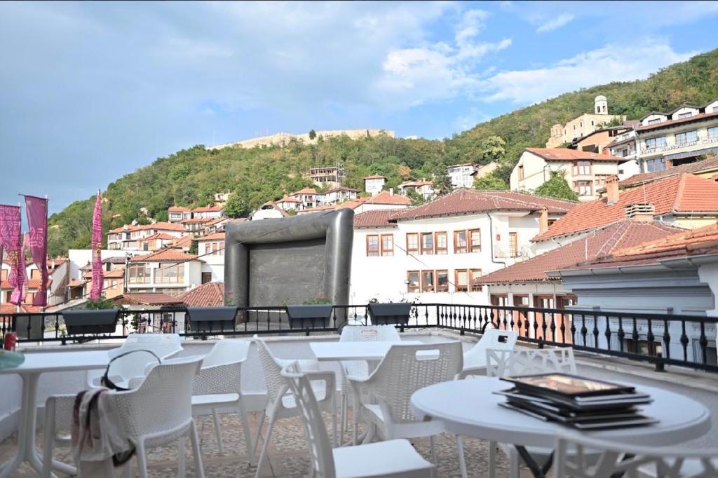 a group of tables and chairs on a balcony at Juna's Hotel in Prizren
