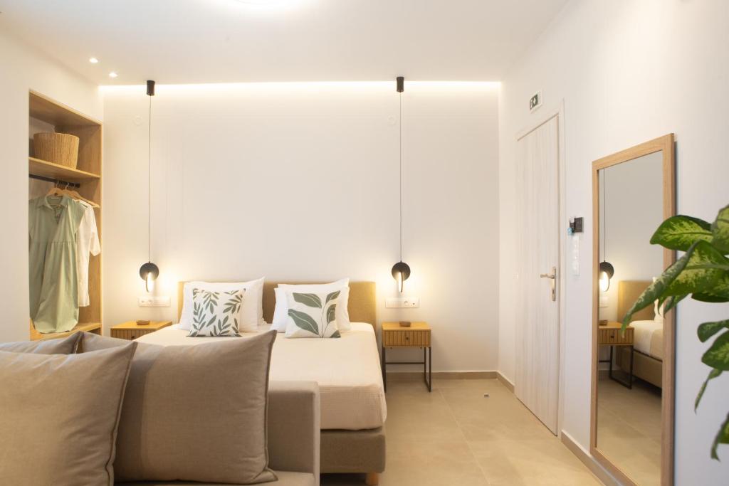 a bedroom with a large bed and a mirror at Calmare suites in Rethymno