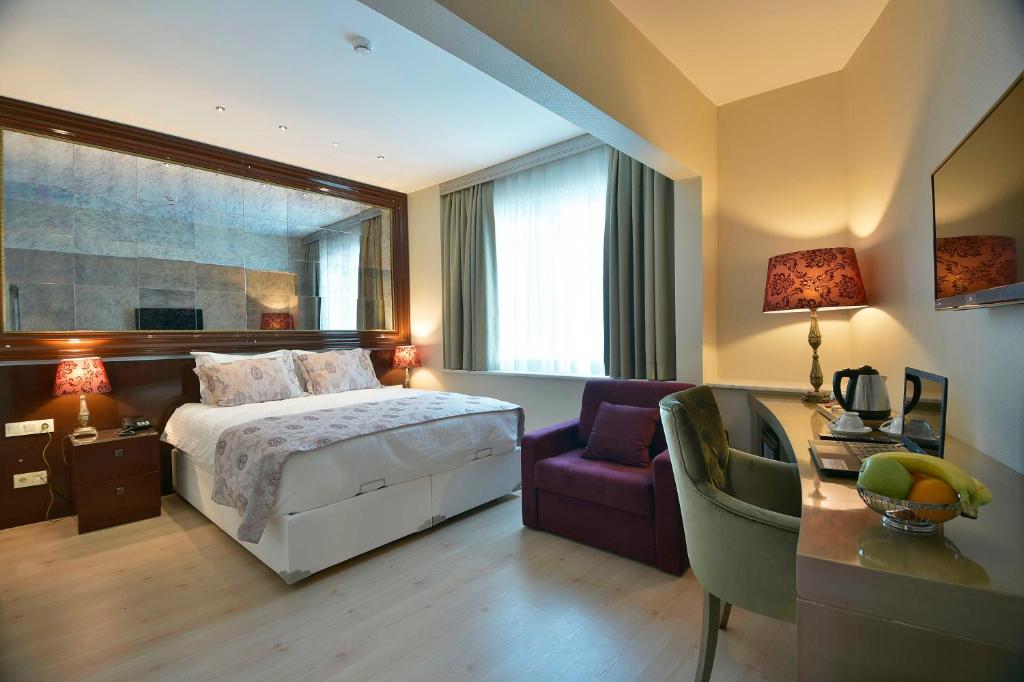 A bed or beds in a room at Adamel City Hotel