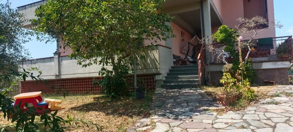 a house with a tree and some chairs in the yard at Affittacamere Casa Sermide in Caniparola di Fosdinovo