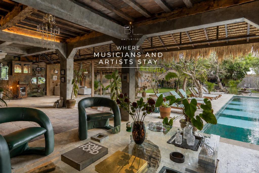 a room with a table and chairs and a pool at The Corduroy Hotel in Canggu