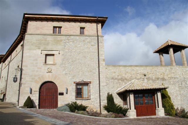 un gran edificio de piedra con una puerta grande en Hotel Palacio Dos Olivos, en Galdeano