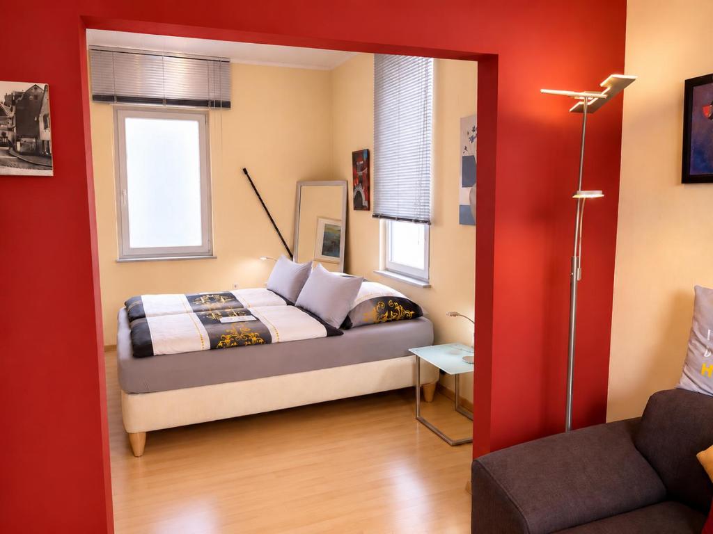 a bedroom with a bed and a red wall at Holiday il Macellaio - nur 5 Min vom Marktplatz in Neustadt an der Weinstraße