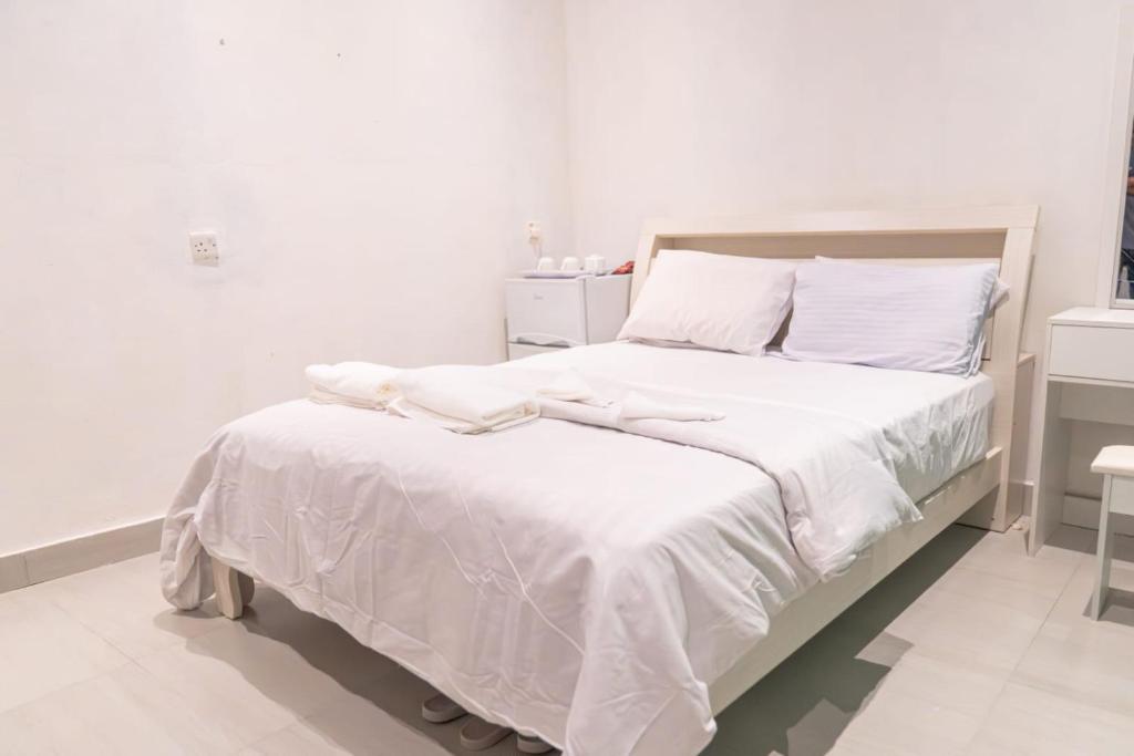 a white bedroom with a bed with white sheets and pillows at Faafu View Maldives in Maldive Islands