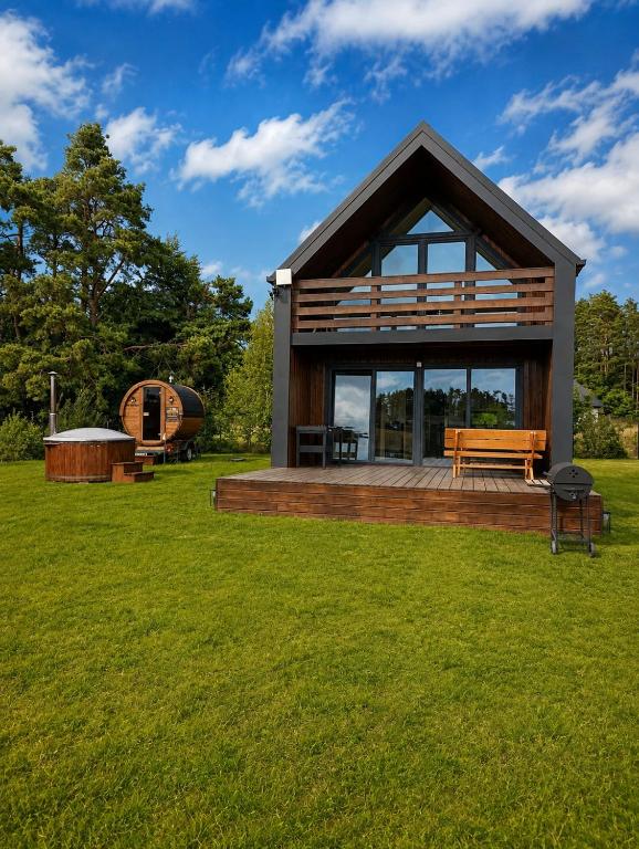 a small house with a bench on a grass field at Stodoła na Kaszubach in Gowidlino