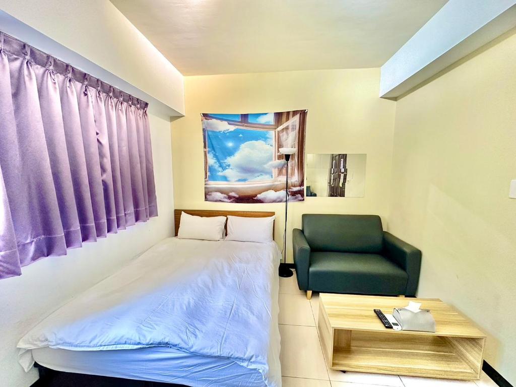 a small room with a bed and a green chair at 卡布里 in Taichung