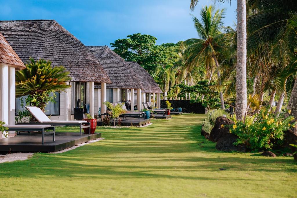 a row of resort cottages with palm trees at Le Lagoto Resort & Spa in Fagamalo