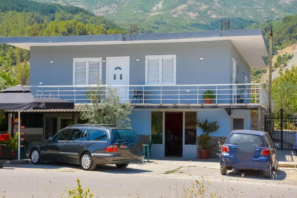 two cars parked in front of a blue building at Guesthouse - VILA QETESIA in Përmet