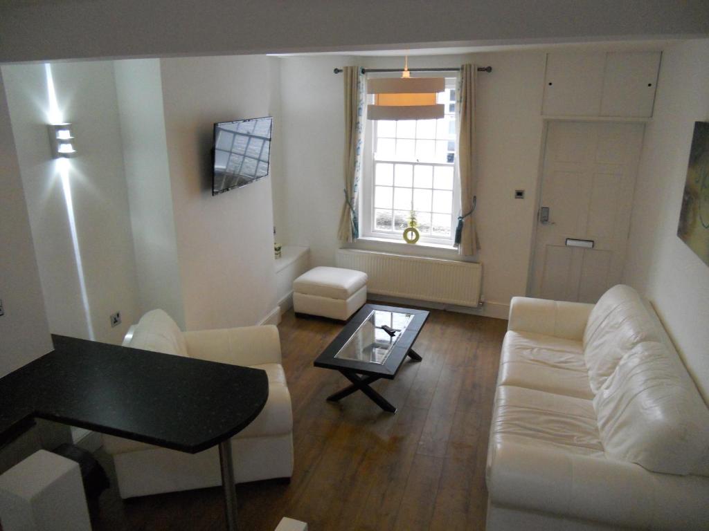 a living room with a white couch and a table at Yarm View Cottages in Yarm