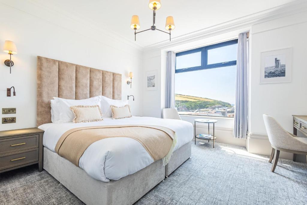 a bedroom with a large bed and a large window at Falcon's Nest Hotel in Port Erin