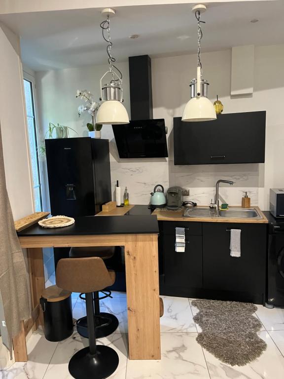 a kitchen with a table and a sink and two lights at Souad in Saint-Vallier