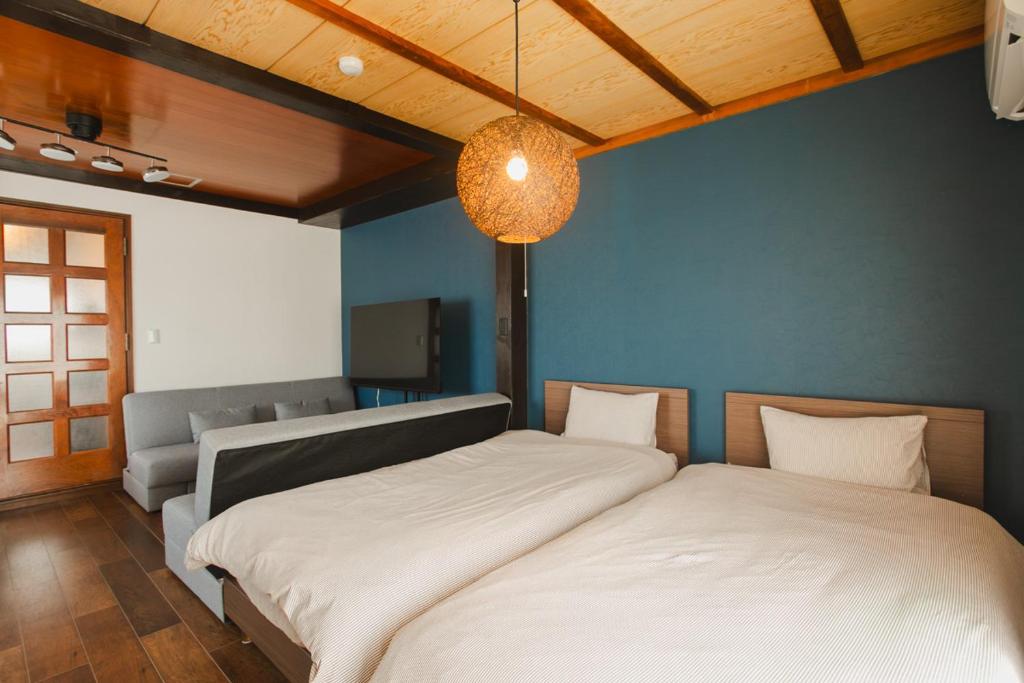 a bedroom with two beds and a blue wall at Numazu Royal Retreat 201 in Numazu