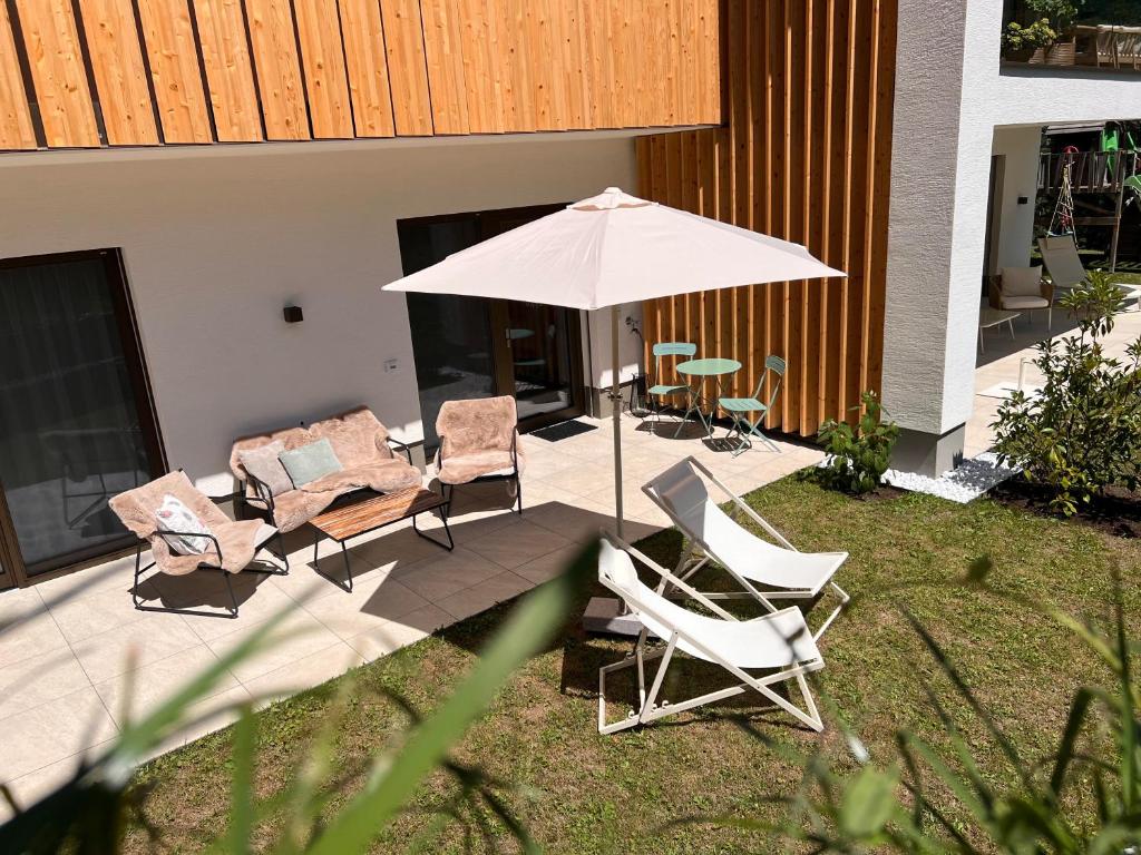 a group of chairs and an umbrella on a patio at Apartment Fidelia in Vandans