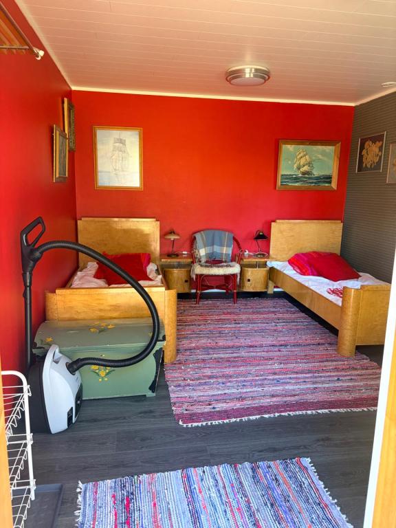 a bedroom with two beds and a red wall at Vierashuone 1 