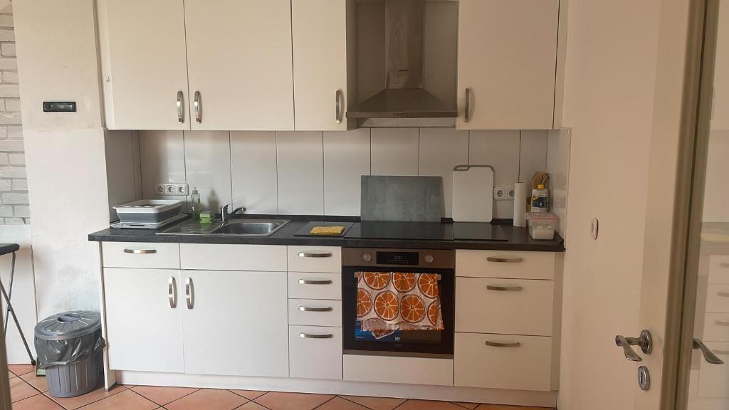 a kitchen with white cabinets and a stove top oven at City-Wohnung Oldenburg-Pferdemarkt in Oldenburg