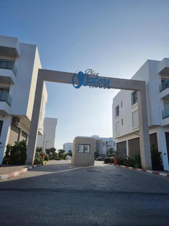 an arch over a parking lot in front of a building at Blue water house in Tamaris