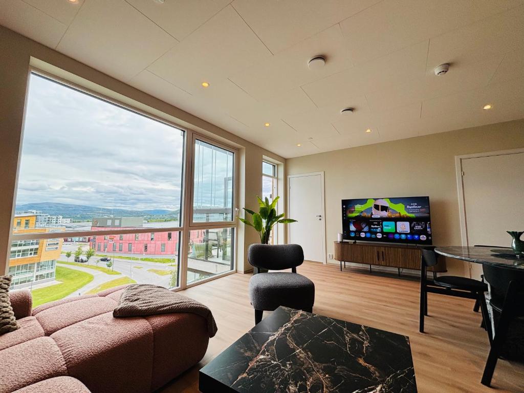 a living room with a couch and a flat screen tv at Arctic Privé Panorama Residence Alta in Alta