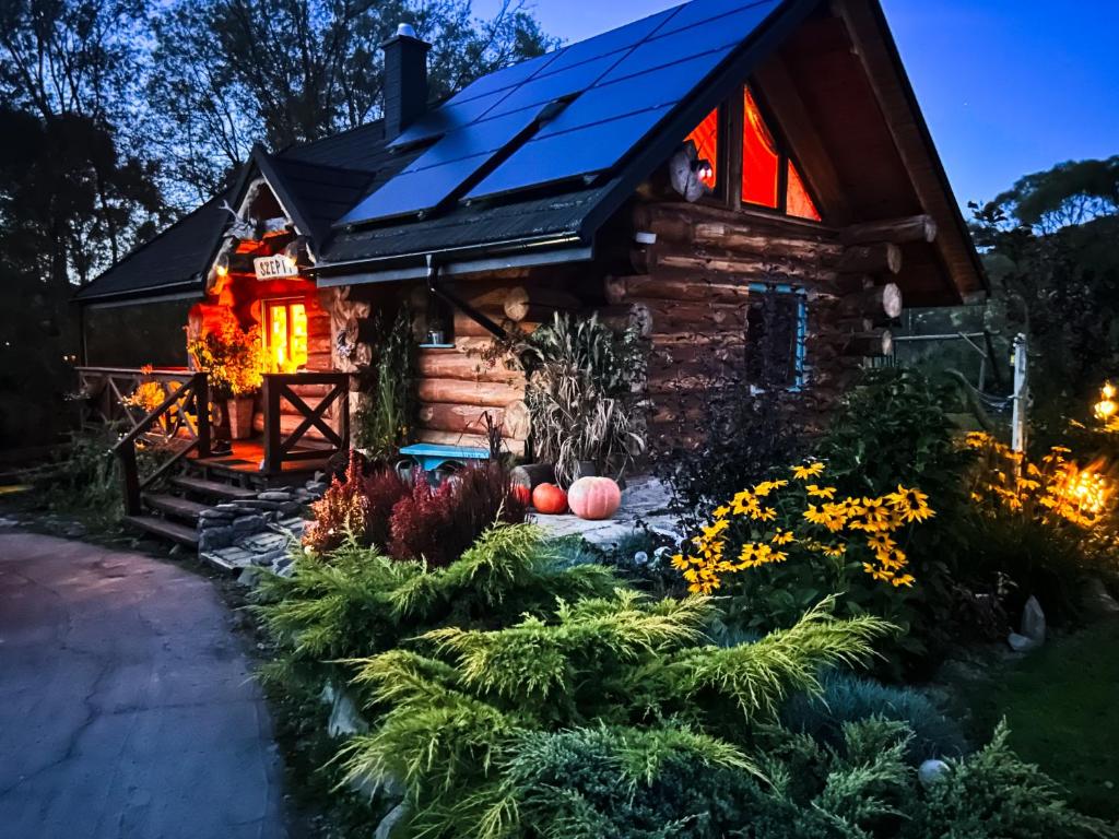 a log cabin with a lit up window at Szepit in Lutowiska