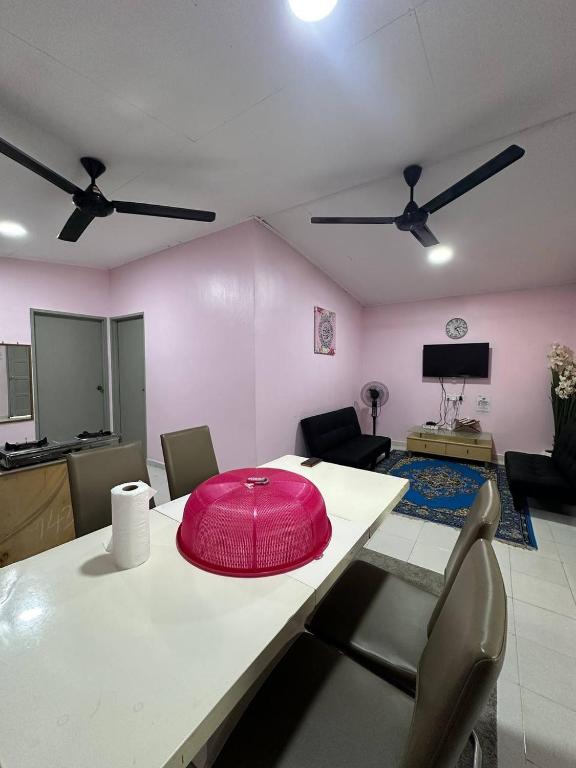 a pink room with a table with a pink hat on it at Homestay D Makmur UNIT 2 in Mersing
