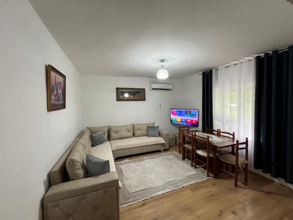 a living room with a couch and a tv at Guesthouse Camping the peaceful of Koman in Gushtë