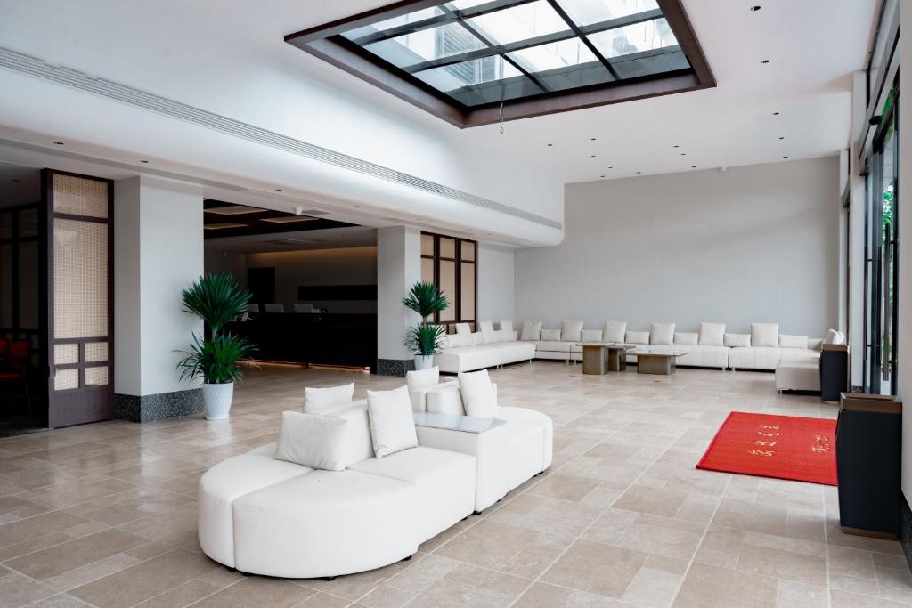 a large lobby with white chairs and a skylight at Vangvieng THAVIKUN HOTEL in Vang Vieng