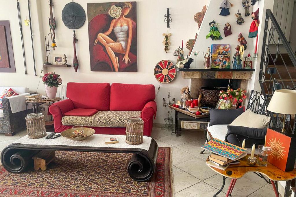 a living room with a red couch and a table at Guesthouse Nuvole in Olbia