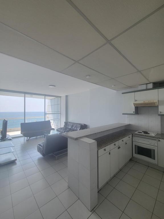 a kitchen with a counter and a couch in a room at Chalet 1BR 1BA with Beach&Pool&Tennis&Basketball in Jounieh