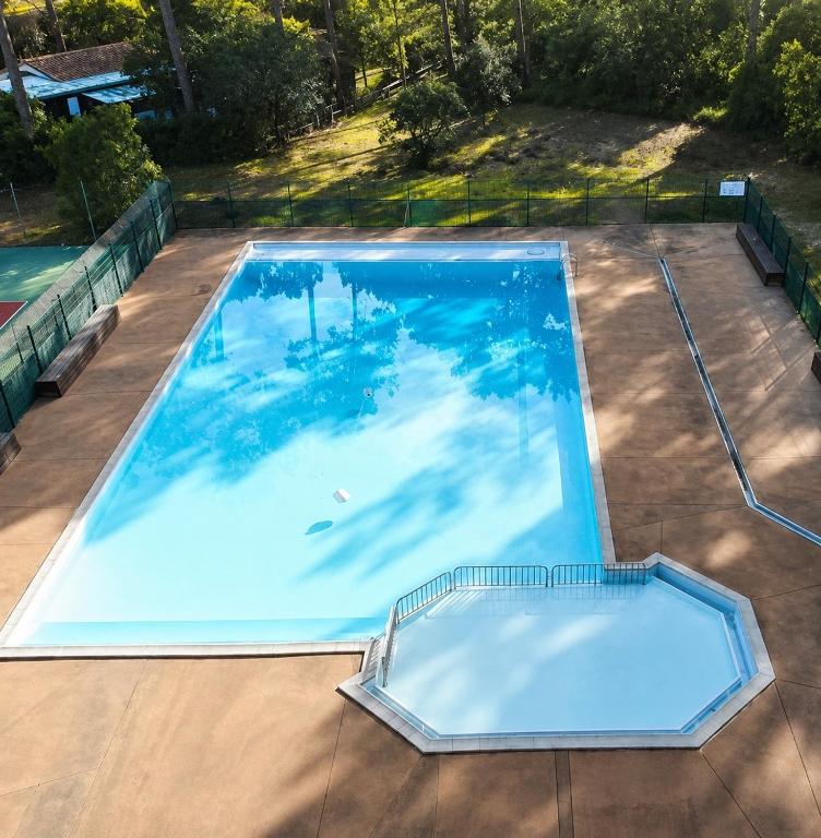 an overhead view of a large swimming pool at Maison huit places Piscine tennis Lacanau plage in Lacanau