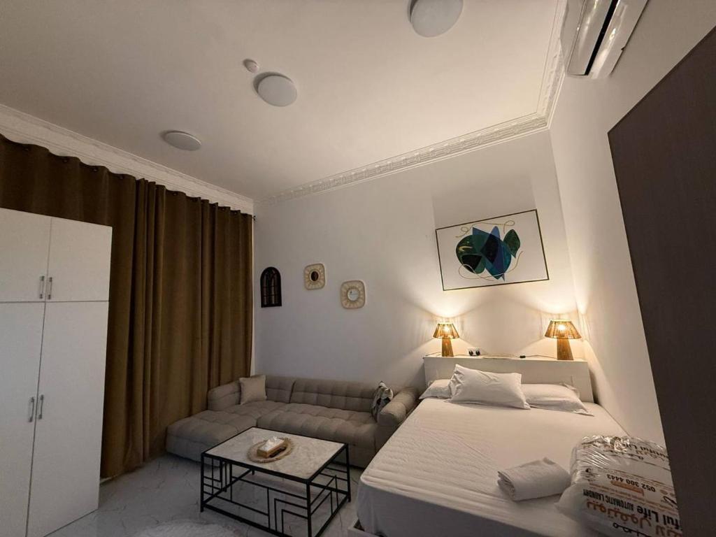 a bedroom with a bed and a couch at Lightmoon studio Jimi in Al Ain