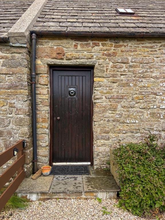 a wooden door in a brick building with a stairs at The Mill O Cara in Orkney