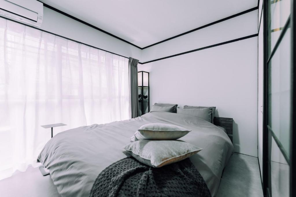 a bedroom with a white bed with pillows on it at Work Ready Stay - Quiet Nakasu 202 in Fukuoka