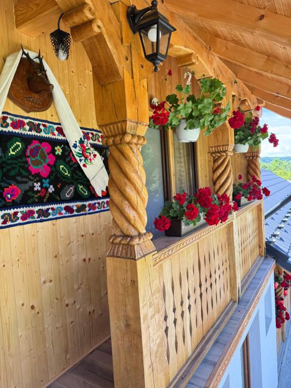 a balcony of a house with flowers on it at Domeniul Ursului in Vadu Izei