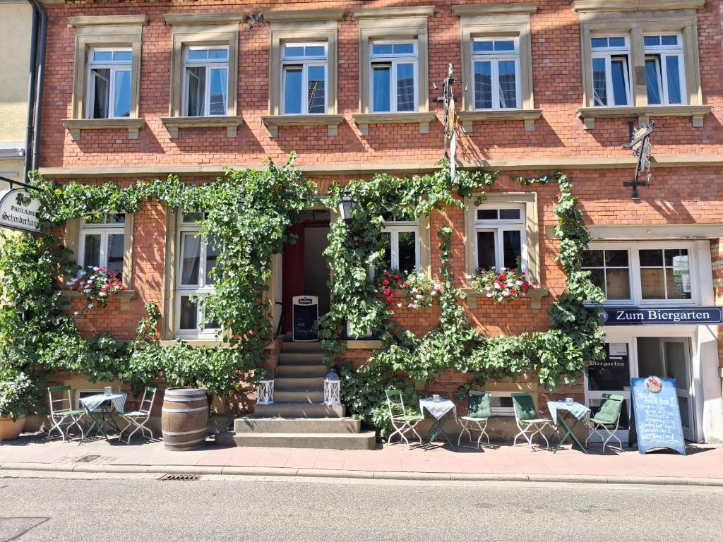 a brick building with chairs and flowers in front of it at Zum Schinderhannes in Waibstadt