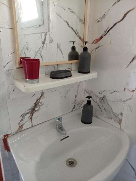 a bathroom sink with two shelves on the wall at Castel bungalow in Palafolls