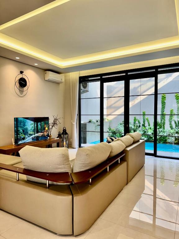 a living room with a couch and a television at Lioravilla15 Kota Baru Parahyangan in Padalarang