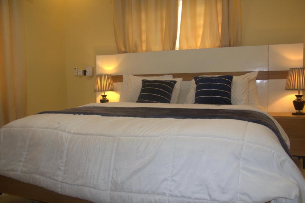 a bedroom with a large white bed with two lamps at Anaviosi Villa in Anum
