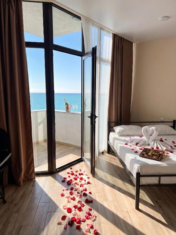 a bedroom with a bed with roses on the floor at Студия у чистейшего Моря! in Gonio
